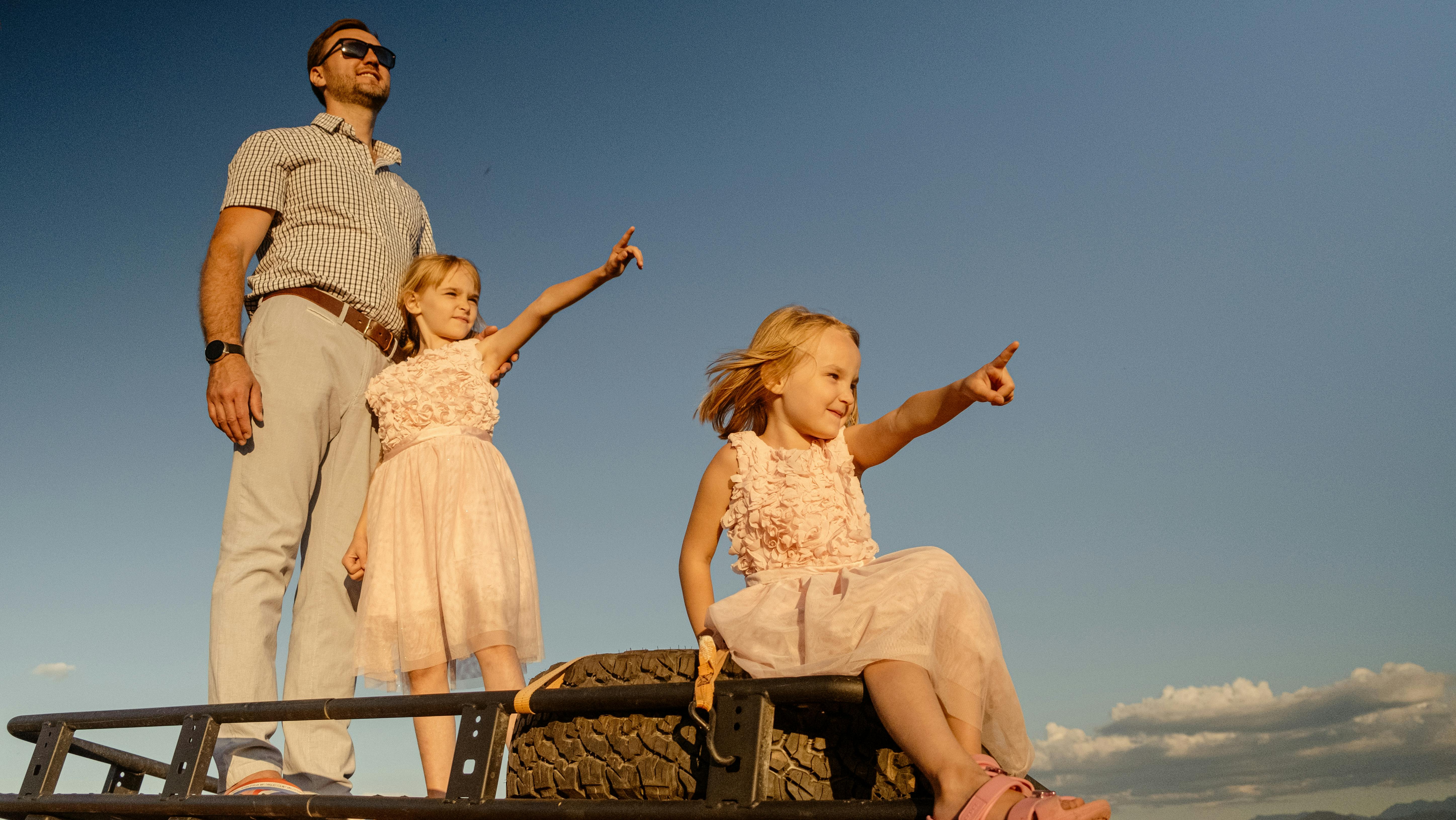 A father and his two daughters enjoying a sunny outdoor adventure together.