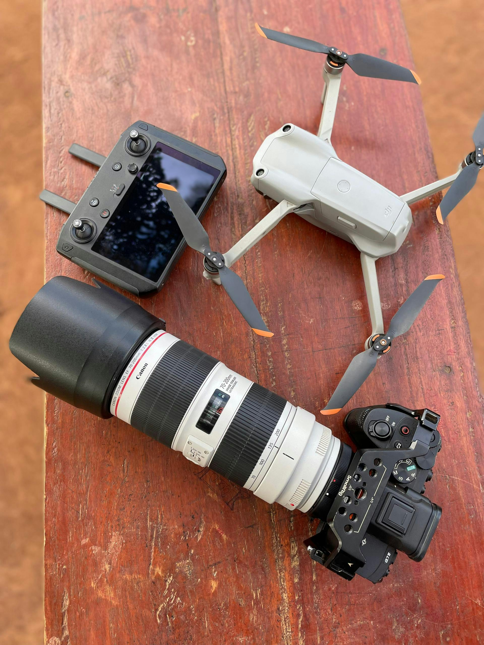 Camera and drone equipment on a wooden surface, ready for action