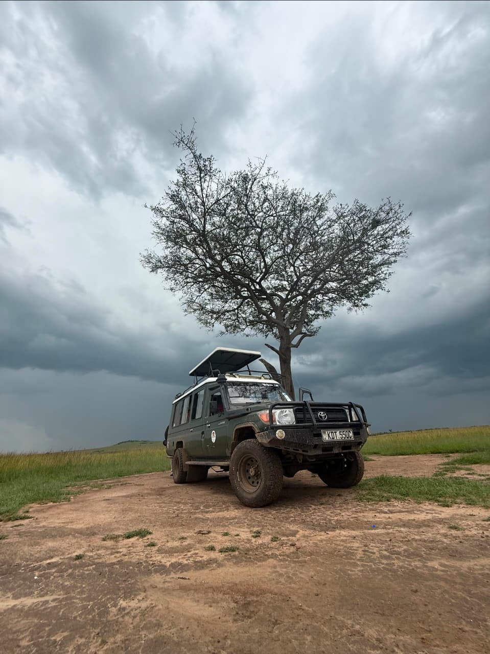 Storm rolling in over the Masai Mara &mdash; our Land Cruiser parked under a lone acacia as the afternoon sky turned. Moments like this are why you don't rush a safari.