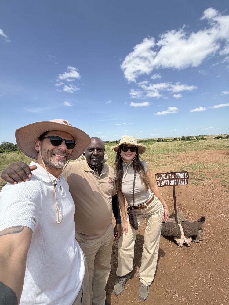 eyond the Plains Safaris clients and guide at the Kenya-Tanzania international boundary marker in the Masai Mara