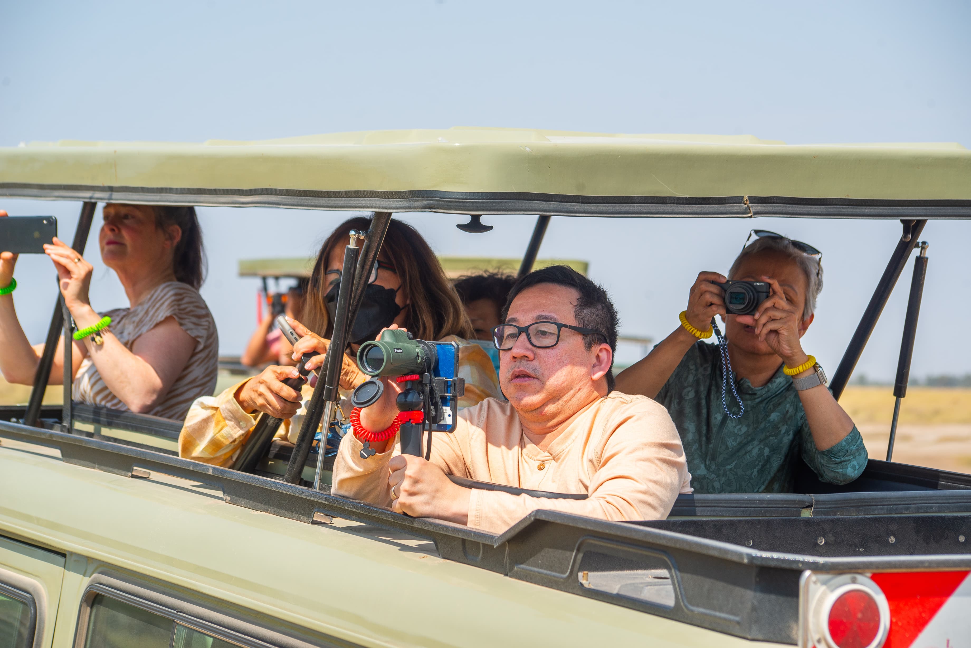 Guests on a Kenya safari holiday game drive photographing wildlife from a 4x4 safari vehicle