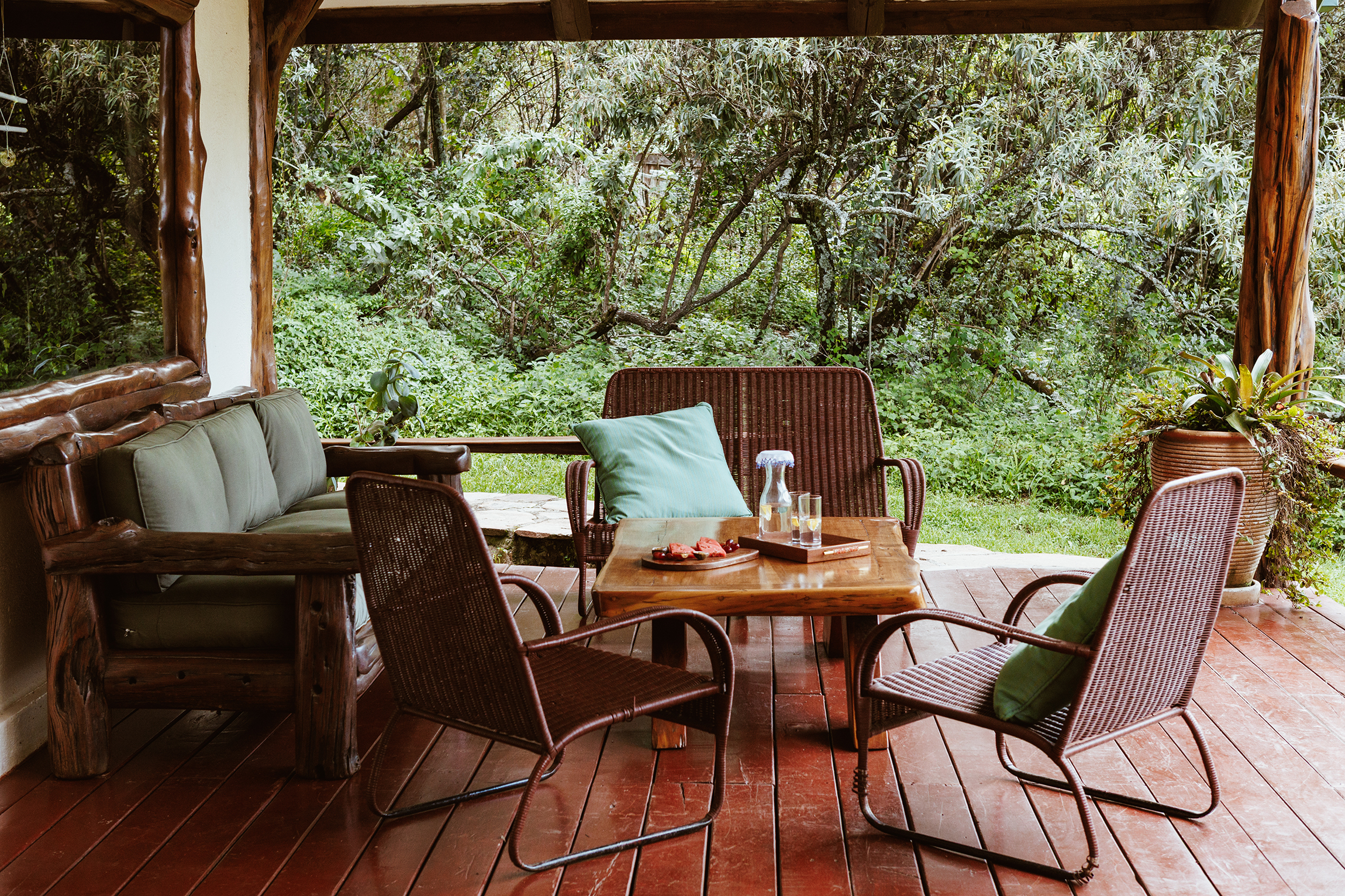 Cozy veranda seating area at Mara Bush Houses by Saruni, surrounded by lush forest scenery.