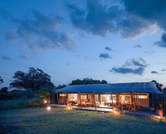 Luxury tented suite at Offbeat Mara Camp glowing at dusk in the Maasai Mara wilderness.