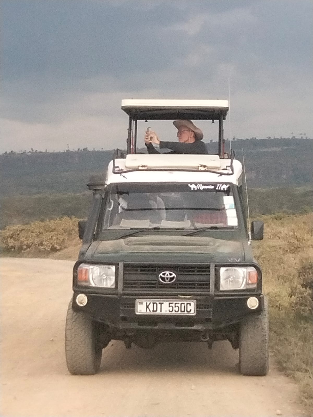 afari guest photographing wildlife from Beyond the Plains Kenya safari vehicle