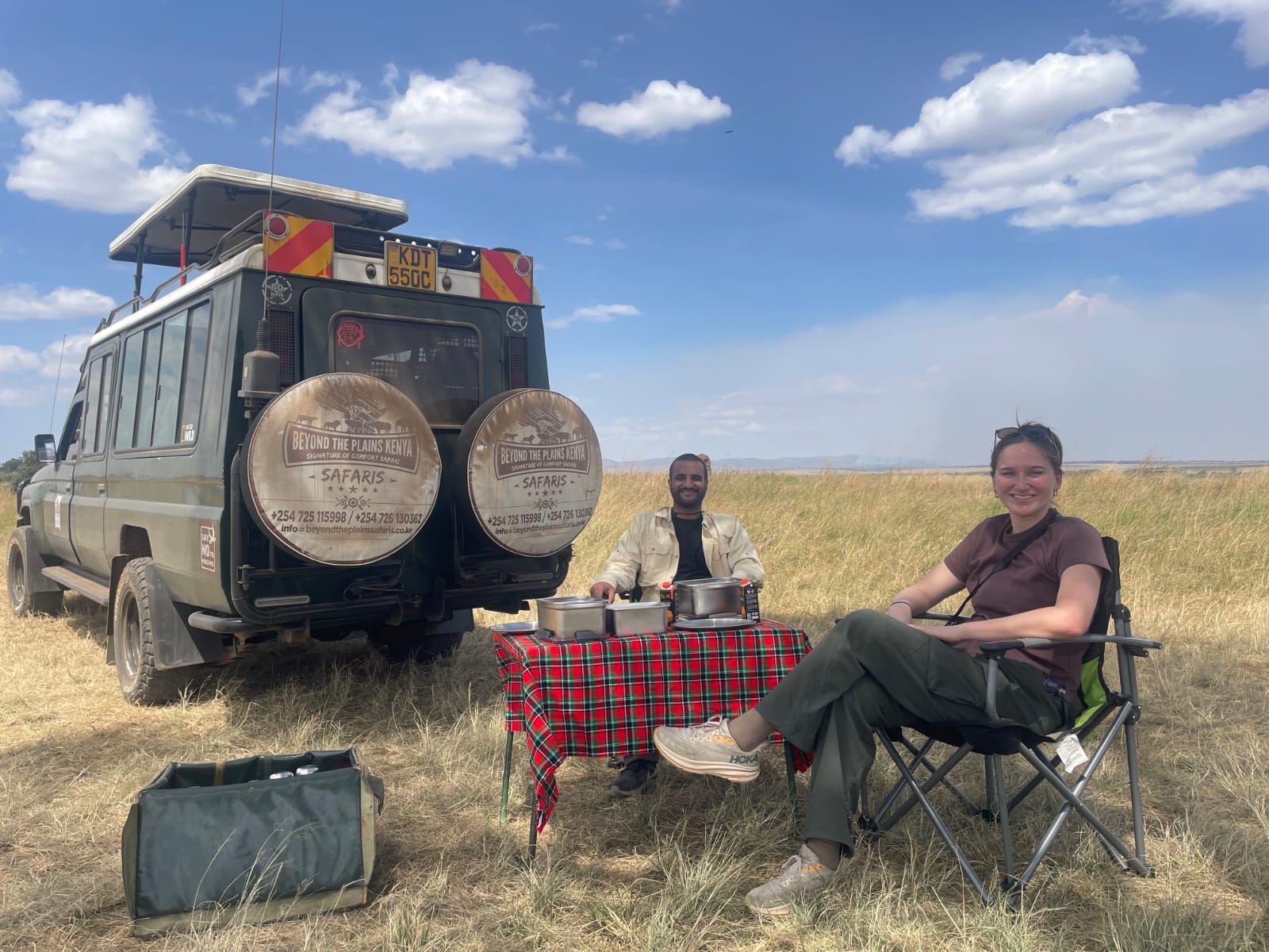 A Beyond the Plains Safaris guide sets up a bush lunch in the Maasai Mara for a traveler on a game drive break