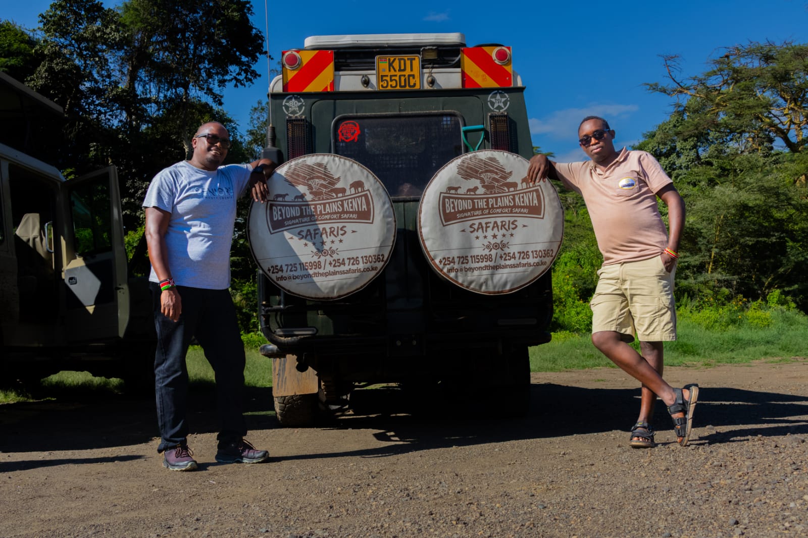 Beyond the Plains Safaris guides standing beside a licensed safari vehicle in the Maasai Mara