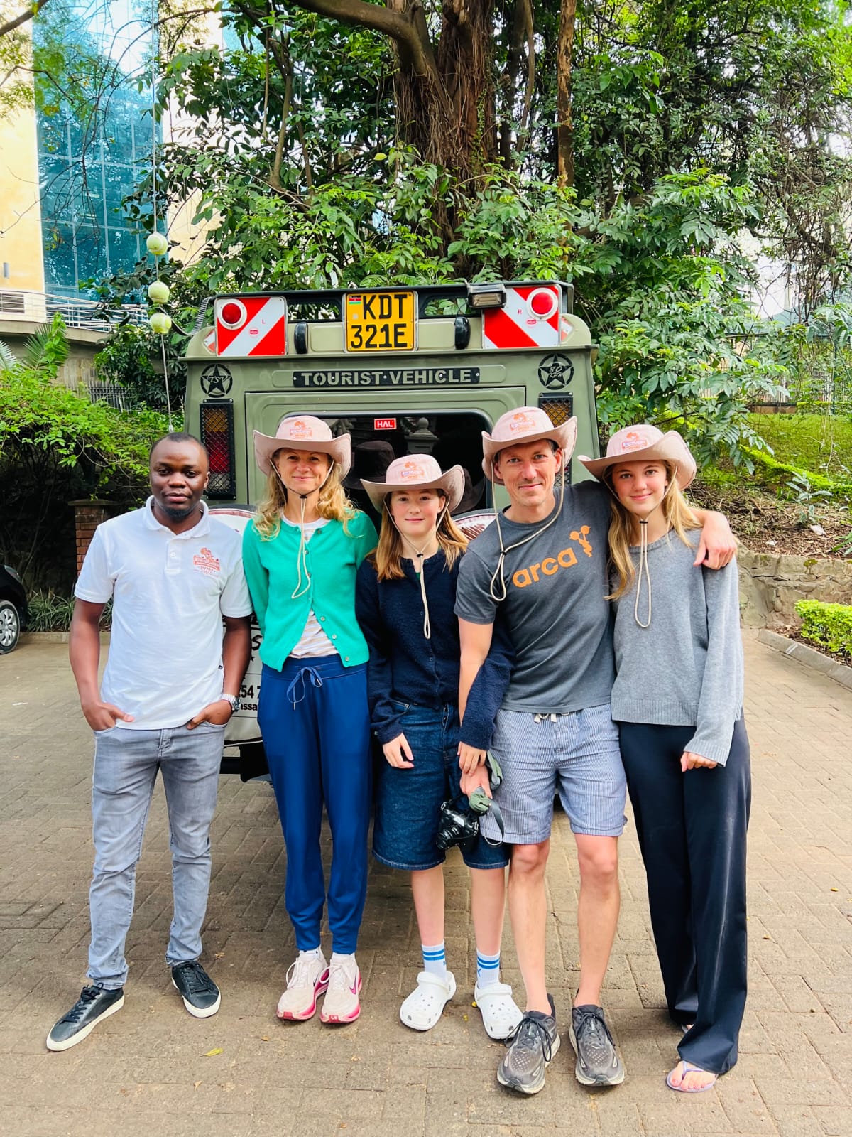 A US family poses with their Beyond the Plains Safaris guide and safari vehicle in Nairobi before departing on a Kenya safari