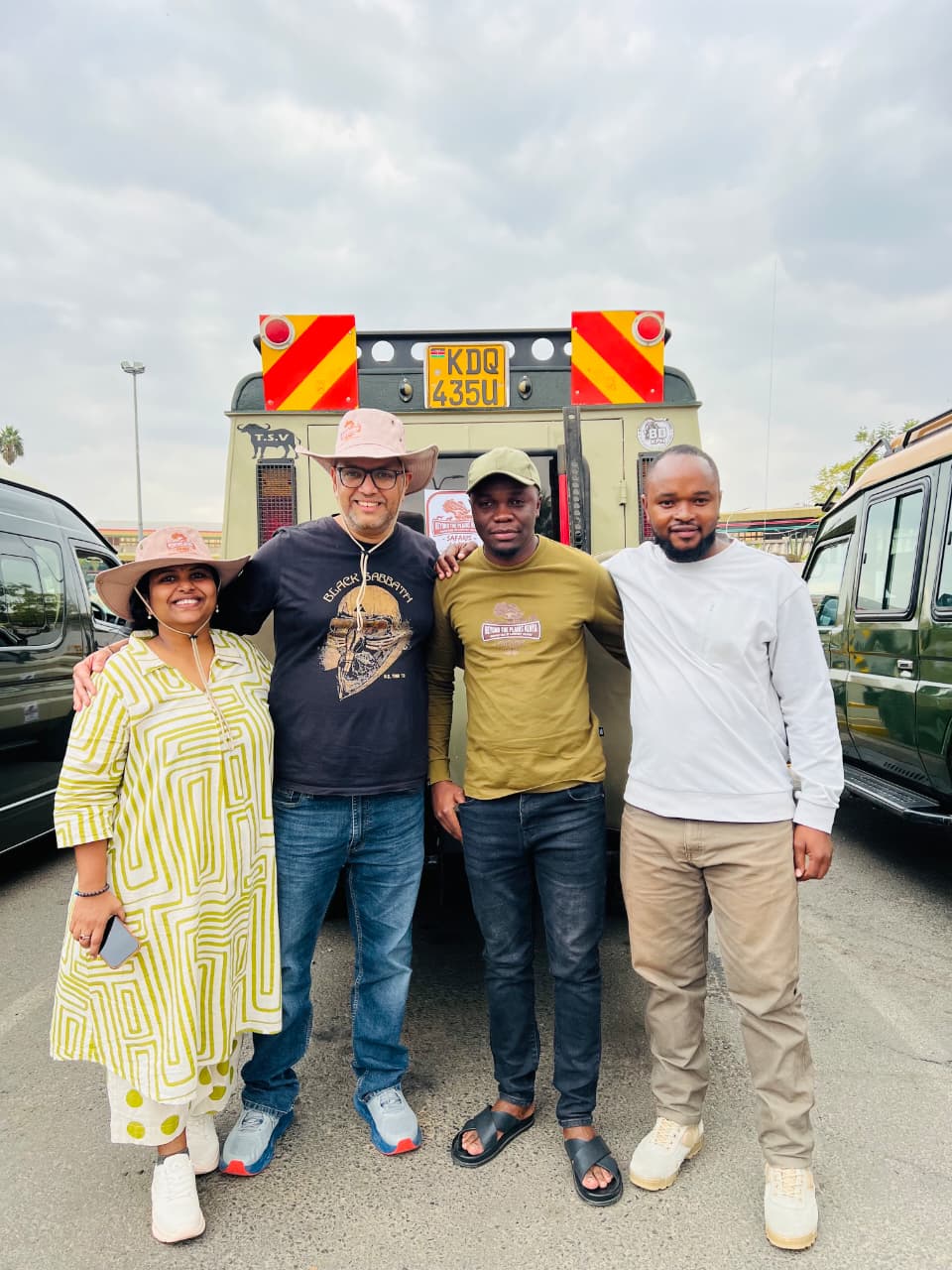 Guests and driver-guide beside a 4x4 safari vehicle in Kenya