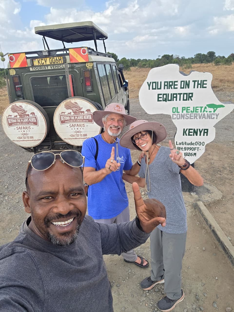 Patrick, Beyond the Plains Safaris guide, with travelers at the equator sign, Ol Pejeta Conservancy, Kenya